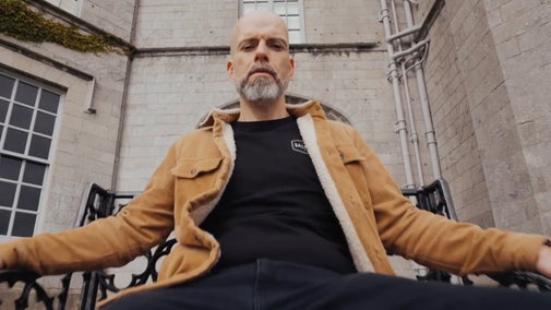 Mr Phormula, aka Ed Holden, sat on a bench outside the house at Plas Newydd